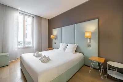 a hotel room with a large bed with white sheets at LE SAINT HONORÉ idéalement situé au cœur de Cannes in Cannes