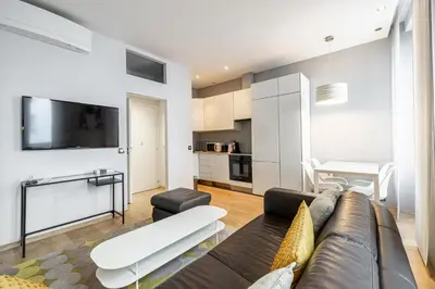 a living room with a couch and a tv at LE SAINT HONORÉ idéalement situé au cœur de Cannes in Cannes