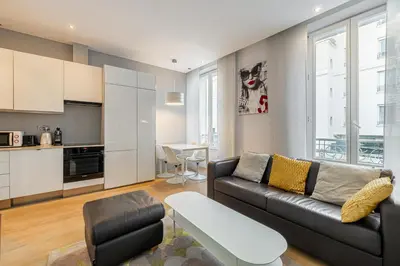 a living room with a couch and a table at LE SAINT HONORÉ idéalement situé au cœur de Cannes in Cannes