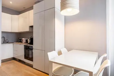 a white kitchen with a white table and chairs at LE SAINT HONORÉ idéalement situé au cœur de Cannes in Cannes