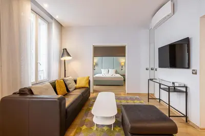 a living room with a couch and a table at LE SAINT HONORÉ idéalement situé au cœur de Cannes in Cannes