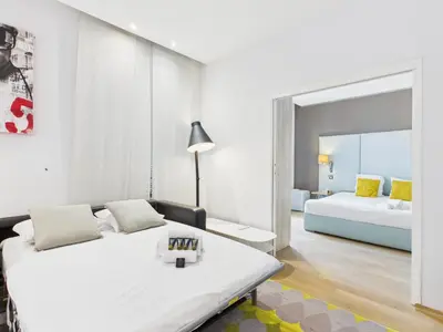 a white room with a bed and a mirror at LE SAINT HONORÉ idéalement situé au cœur de Cannes in Cannes