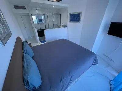 a bedroom with a bed with blue pillows at Modern Chic Seaview Appartement in Cannes