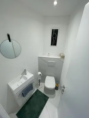 a white bathroom with a sink and a toilet at Modern Chic Seaview Appartement in Cannes