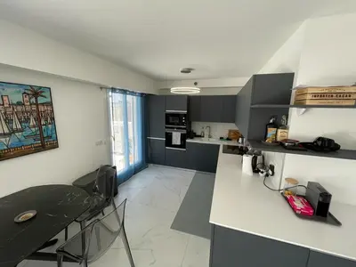 a kitchen with a counter and a table in a room at Modern Chic Seaview Appartement in Cannes