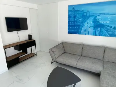 a living room with a couch and a tv at Modern Chic Seaview Appartement in Cannes
