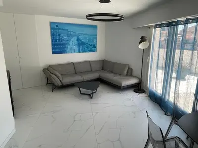 a living room with a couch and a table at Modern Chic Seaview Appartement in Cannes