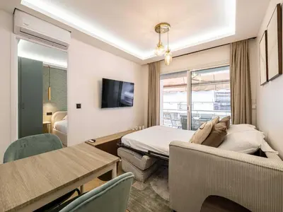 a hotel room with a bed and a table and chairs at Elegant Apt with balcony 1BD 4P - Croisette Cannes in Cannes