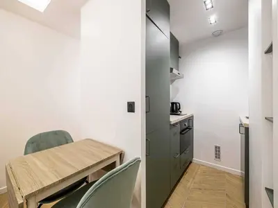 a room with a table and chairs and a kitchen at Elegant Apt with balcony 1BD 4P - Croisette Cannes in Cannes