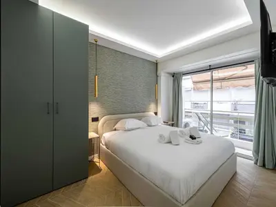 a bedroom with a bed and a large window at Elegant Apt with balcony 1BD 4P - Croisette Cannes in Cannes
