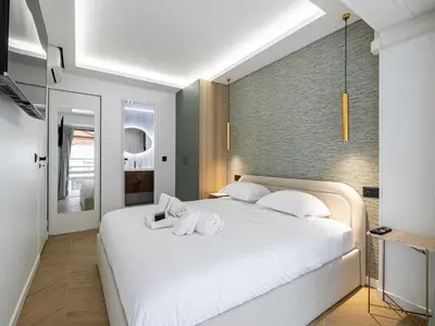 a bedroom with a large white bed with two towels at Elegant Apt with balcony 1BD 4P - Croisette Cannes in Cannes
