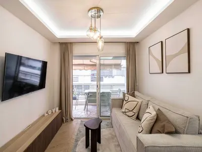 a living room with a couch and a tv at Elegant Apt with balcony 1BD 4P - Croisette Cannes in Cannes