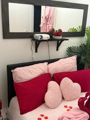 a bed with red and pink pillows and a mirror at Romantic Room - Jaccuzi Privé -Appartement Cannes in Cannes