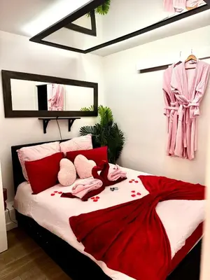 a bedroom with a bed with a red dress on it at Romantic Room - Jaccuzi Privé -Appartement Cannes in Cannes