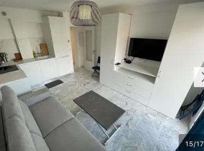 a living room with a couch and a flat screen tv at Mistral Seaside Studio - 200m de la Plage in Cannes