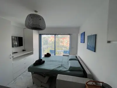 a living room with a bed and a large window at Mistral Seaside Studio - 200m de la Plage in Cannes