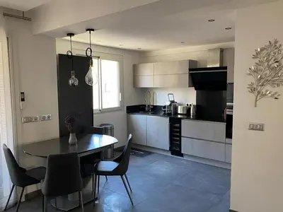 a kitchen with a table and chairs in a room at Appartement MIRAMAR 5 couchages in Cannes