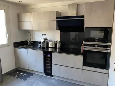 a kitchen with a black counter top in a room at Appartement MIRAMAR 5 couchages in Cannes