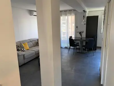a living room with a couch and a table and chairs at Appartement MIRAMAR 5 couchages in Cannes