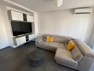 a living room with a couch and a flat screen tv at Appartement MIRAMAR 5 couchages in Cannes