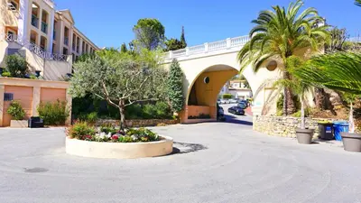 a courtyard with a tree in a flower bed in front of a building at Cannes Passion in Cannes