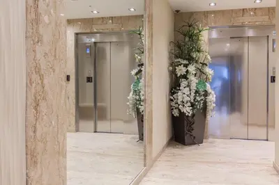 a mirror in a hallway with elevators with flowers at Luxury Croisette Sea view facing Palais in Cannes