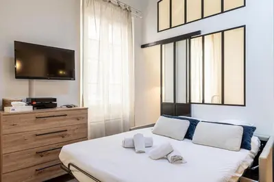 a bedroom with a bed with a tv on the wall at 13 ANDRE2 - Very nice duplex apartment, 100m from La Croisette and beaches in Cannes
