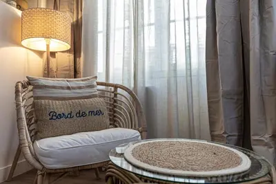 a room with a chair and a table and a lamp at 13 ANDRE2 - Very nice duplex apartment, 100m from La Croisette and beaches in Cannes