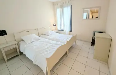 a white bedroom with a bed and a window at Ref FLORIAN by Palmes dProperties in Cannes