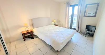 a bedroom with a white bed and a television at Ref FLORIAN by Palmes dProperties in Cannes