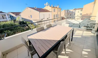 a wooden table and chairs on a balcony at Ref FLORIAN by Palmes dProperties in Cannes