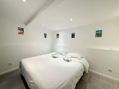 a bedroom with a bed with two candles on it at A076 Appart 6 pers chambre et terrasse au Suquet in Cannes
