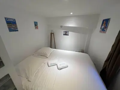 a bedroom with a white bed with two slippers on it at A076 Appart 6 pers chambre et terrasse au Suquet in Cannes