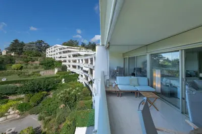 a balcony of a house with a view of the ocean at Riviera Escape – Sea View, Pool & Tennis in Cannes