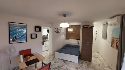 a small bedroom with a bed and a table at Studio F1 avec jardin, proche du Palais des festivals et des plages in Cannes