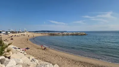 a beach with the ocean and some waves at Studio F1 avec jardin, proche du Palais des festivals et des plages in Cannes