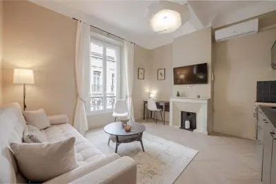a living room with a white couch and a fireplace at Renovated 1-Br Apartment Heart of Cannes in Cannes