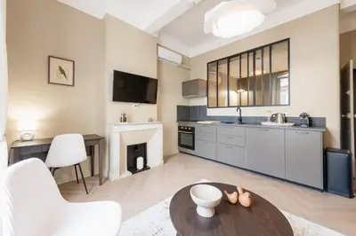 a living room with a kitchen and a table at Renovated 1-Br Apartment Heart of Cannes in Cannes