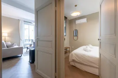 a bedroom with a bed and a couch and a window at Renovated 1-Br Apartment Heart of Cannes in Cannes