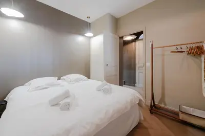 a bedroom with a white bed with towels on it at Renovated 1-Br Apartment Heart of Cannes in Cannes