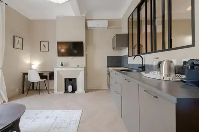 a kitchen with a table and a dining room at Renovated 1-Br Apartment Heart of Cannes in Cannes