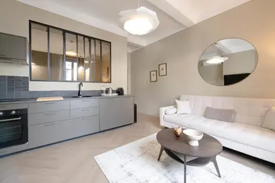 a living room with a white couch and a table at Renovated 1-Br Apartment Heart of Cannes in Cannes