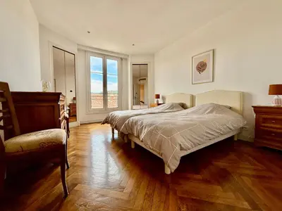 a bedroom with two beds and a large window at Appartement HOCHE CANNES centre-ville in Cannes