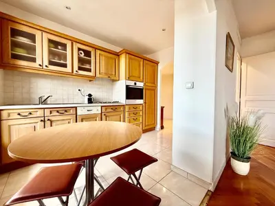 a kitchen with a wooden table and red chairs at Appartement HOCHE CANNES centre-ville in Cannes