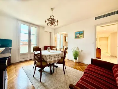 a living room with a table and a couch at Appartement HOCHE CANNES centre-ville in Cannes
