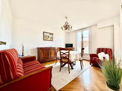 a living room with a red couch and a table at Appartement HOCHE CANNES centre-ville in Cannes