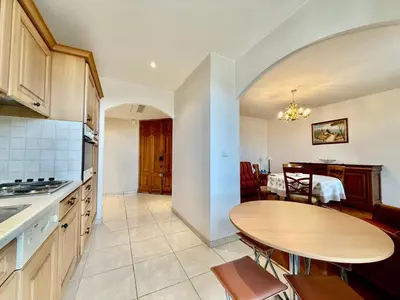a kitchen with a table and a dining room at Appartement HOCHE CANNES centre-ville in Cannes