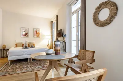 a room with a table and a bed and a mirror at 13 ANDRE1 - Hotel-Style Suite Studio 50m from Croisette in Cannes