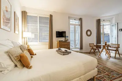 a bedroom with a large white bed and a table at 13 ANDRE1 - Hotel-Style Suite Studio 50m from Croisette in Cannes