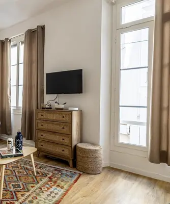 a living room with a television on a dresser and a window at 13 ANDRE1 - Hotel-Style Suite Studio 50m from Croisette in Cannes